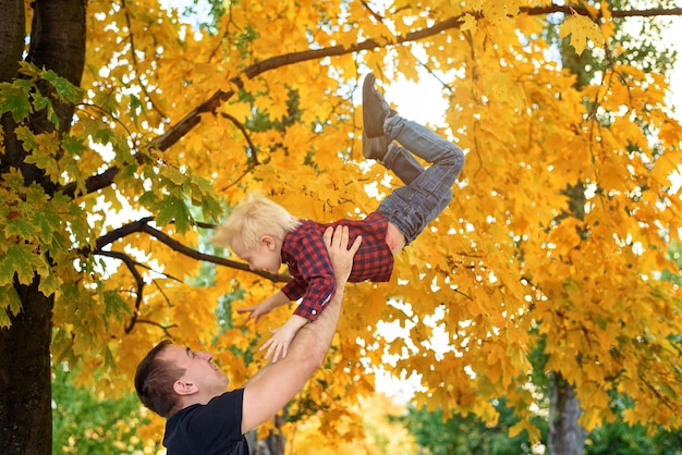 Père vomit son fils blond Feuilles jaunes sur fond Concept de famille