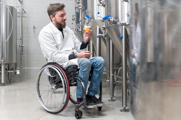 Personne handicapée qui utilise un fauteuil roulant travaillant à l'usine de bière artisanale