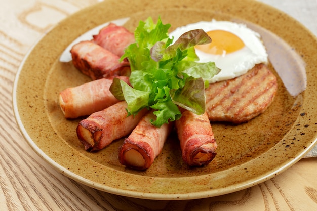 Photo petit déjeuner anglais. roulé d'œufs au plat et de bacon