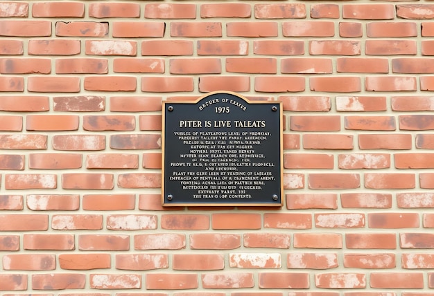 Photo photo représentant un vieux mur de briques avec une plaque historique