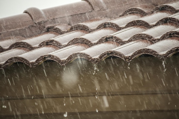 Pluie tombant du toit de la maison