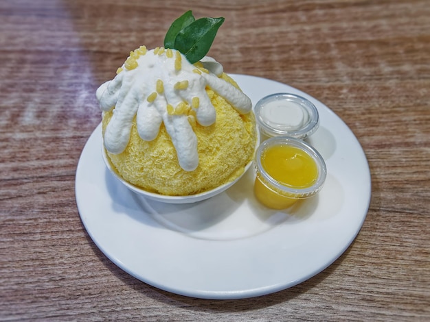 Portrait d'un bol de crème glacée à la mangue sucrée avec garniture à la crème de noix de coco