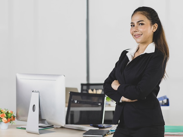 Portrait d'une femme adulte asiatique est des gens de bureau portant un costume debout et croisé les bras en regardant la caméra, un regard confiant et souriant pour être heureux avec un sourire sur le visage.