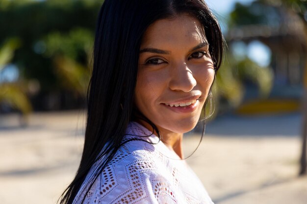 Photo portrait d'une femme biraciale heureuse souriante sur une plage ensoleillée