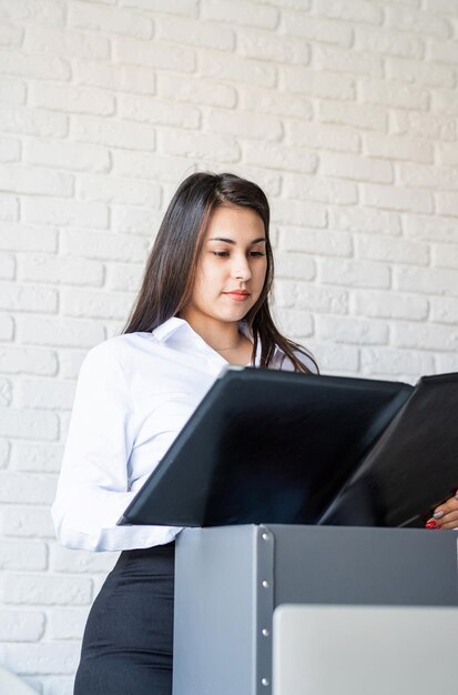 Photo portrait d'une jeune avocate travaillant avec des documents sur son espace de travail