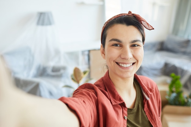 Photo portrait de jeune femme heureuse faisant portrait de selfie à la maison