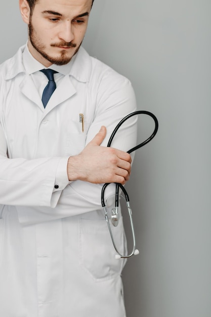 Portrait d'un médecin sympathique isolé sur gris