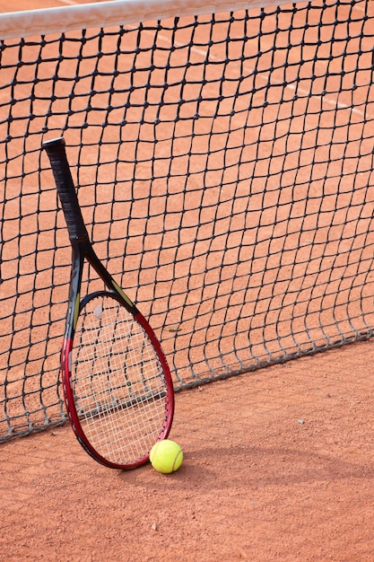 Raquette de tennis et balles sur terre battue