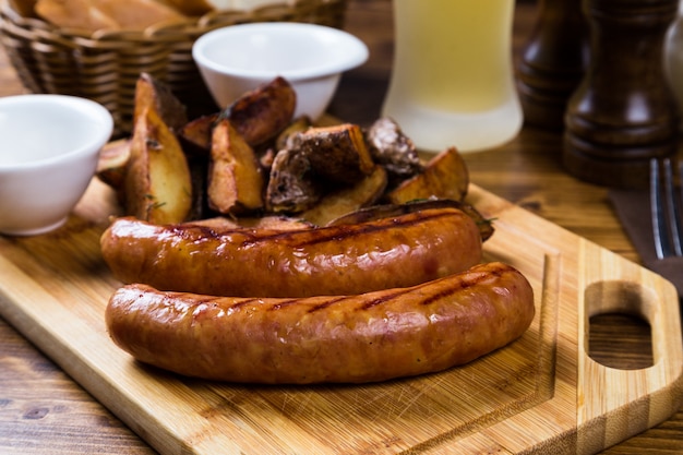 Photo saucisses grillées avec pomme de terre rôtie aux épices