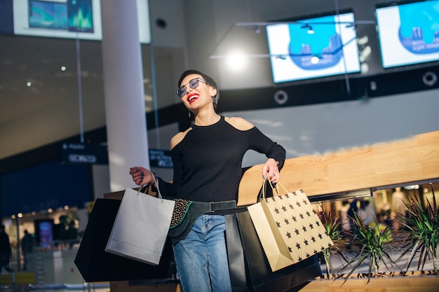 Shopper marchant dans le centre commercial ou centre commercial avec des sacs à provisions