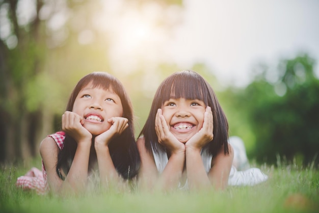 Photo des sœurs mignons souriantes allongées sur le champ