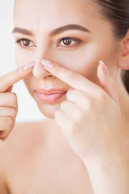 Soin de la peau. Belle femme pressant un bouton au miroir de la salle de bain