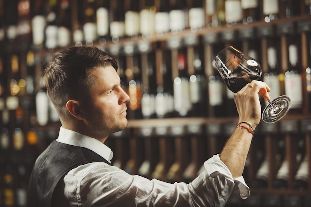 Photo un sommelier masculin dégustant du vin rouge à la cave un expert professionnel apprécie la qualité de la boisson