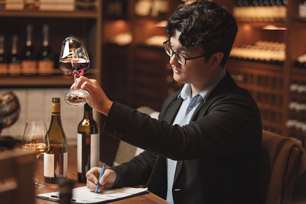 Photo un sommelier professionnel organise une dégustation de vin assis à table dans la cave