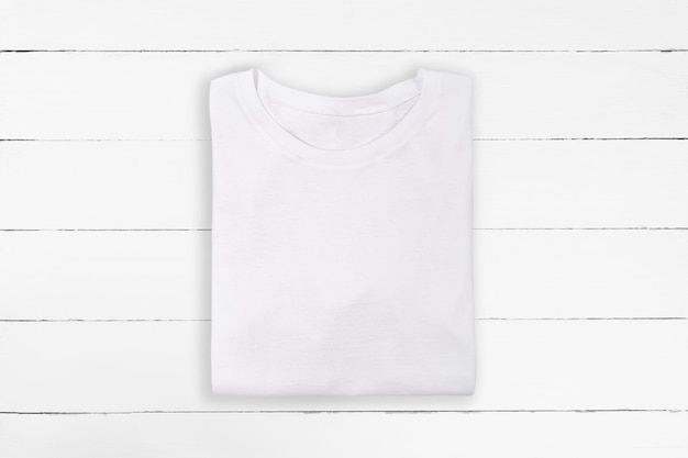 T-shirt blanc plié blanc sur fond de bois blanc