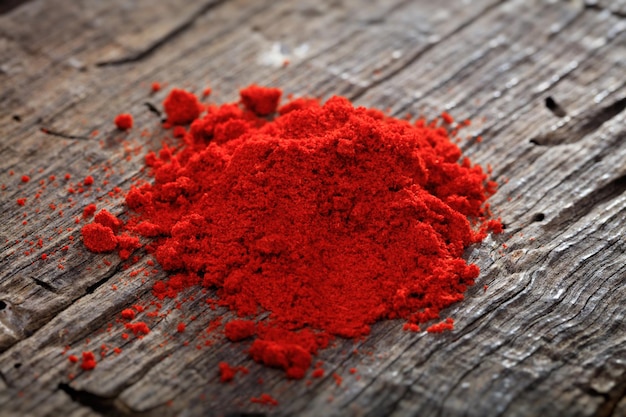 Un tas de poudre de paprika sur une surface en bois