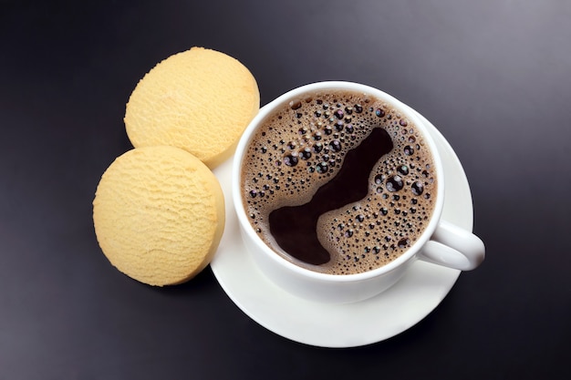 Tasse blanche de café noir avec des biscuits