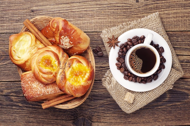 Tasse à café et petits pains sucrés sur la table en bois