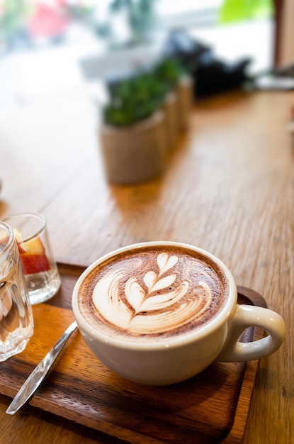 Photo une tasse de latte sur une table en bois.