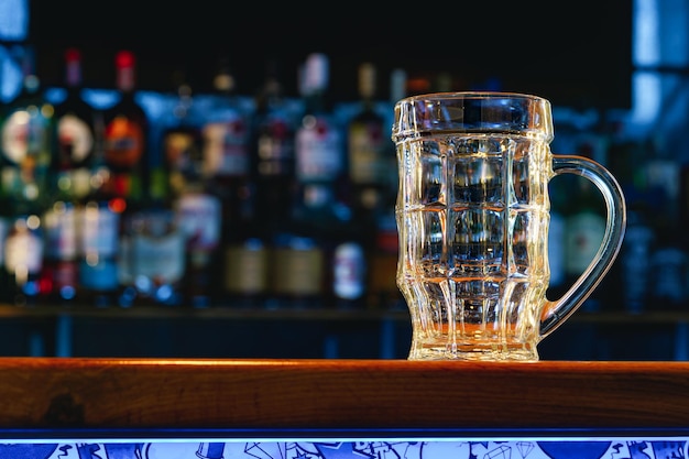 Verre à bière vide sur un comptoir de bar en bois