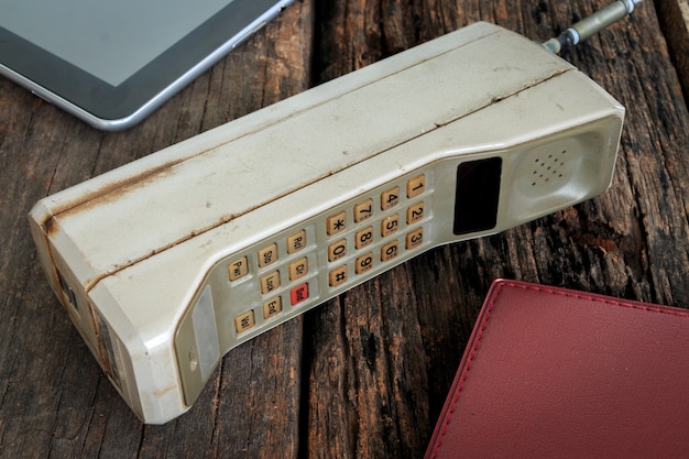 Vieux téléphone portable mis sur la table en bois