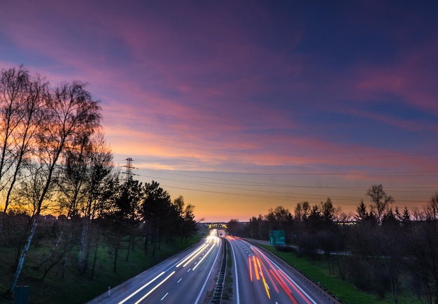 Photo des voitures sur la route contre le ciel au coucher du soleil.