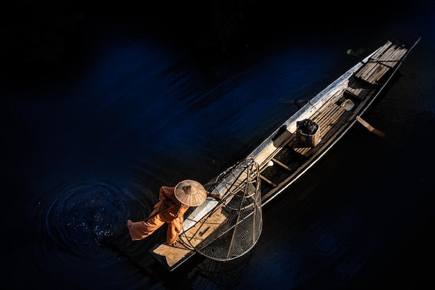 Photo vue d'angle élevé d'un pêcheur avec un bateau dans la rivière