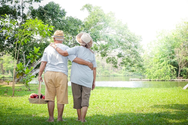 Photo vue arrière d'un homme avec les bras levés sur l'herbe contre les arbres