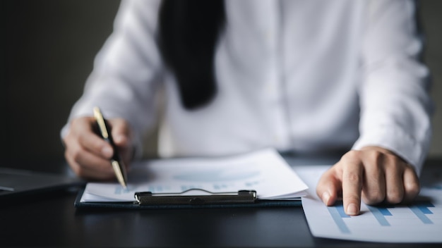 Vue rapprochée d'un homme d'affaires pointant vers un graphique à barres sur un document financier de l'entreprise préparé par le Département des finances pour une réunion avec des partenaires commerciaux Concept financier