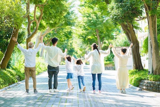 Photo 3 generation family holding hands in greenly street