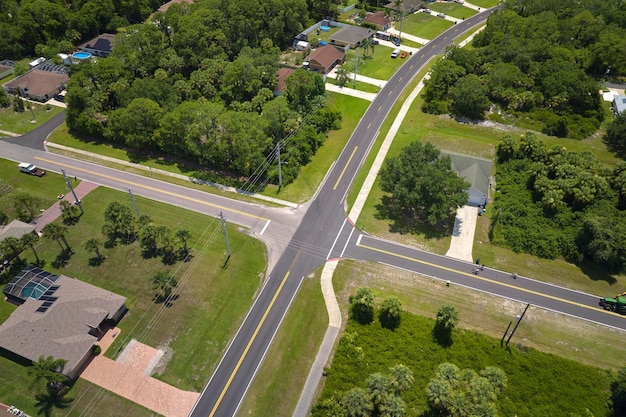 Aerial view of american small town in Florida with private homes between green palm trees and suburban streets in quiet residential area