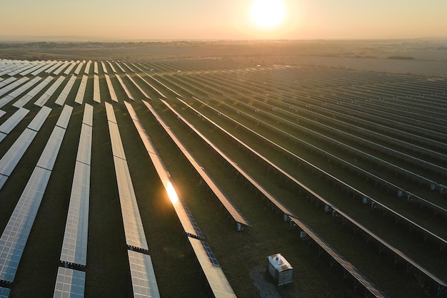 Aerial view of big sustainable electric power plant with many rows of solar photovoltaic panels for producing clean electrical energy at sunset Renewable electricity with zero emission concept