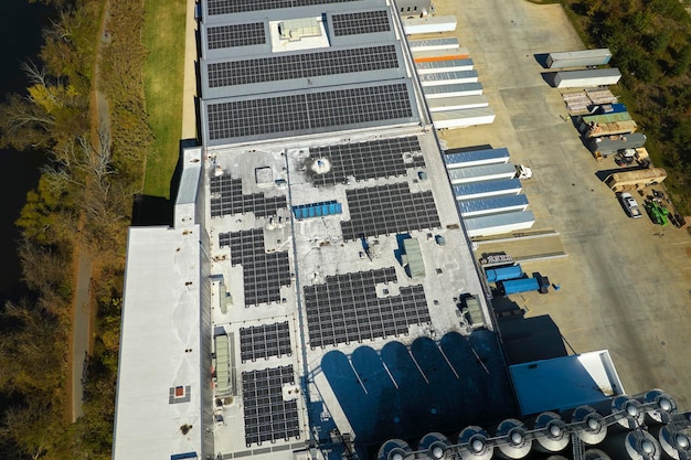 Aerial view of blue photovoltaic solar panels mounted on industrial building roof for producing green ecological electricity Production of sustainable energy concept