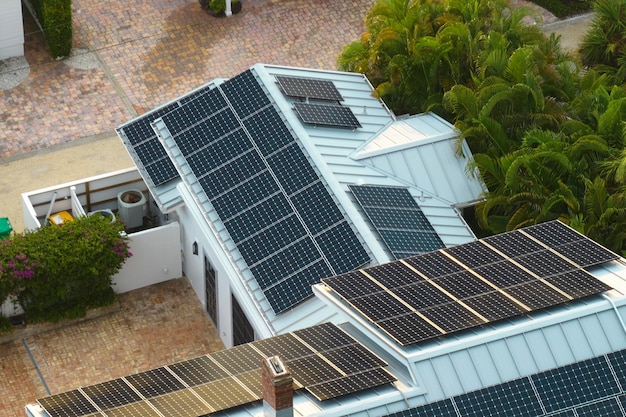 Aerial view of expensive american home roof with blue solar photovoltaic panels for producing clean ecological electric energy Investing in renewable electricity for retirement income