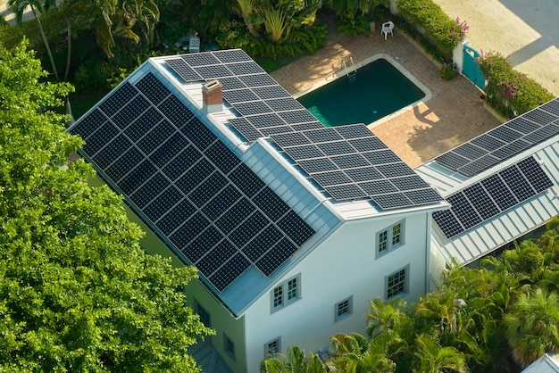 Aerial view of expensive american home roof with blue solar photovoltaic panels for producing clean ecological electric energy Investing in renewable electricity for retirement income