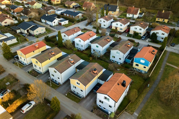 Aerial view of residential houses with red roofs and streets with parked cars in rural town area.