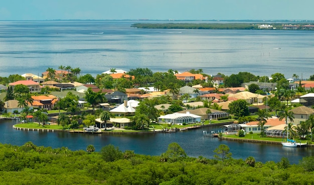 Aerial view of residential suburbs with private homes located near wildlife wetlands with green vegetation on sea shore Living close to nature concept