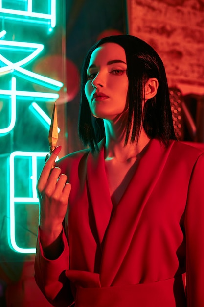 Anime woman in a red suit with short hair cut, black hair. A killer girl in a red jacket with a dagger in her hand. Beauty portrait