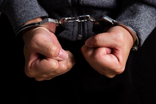 Photo arrested man's hand with handcuffs