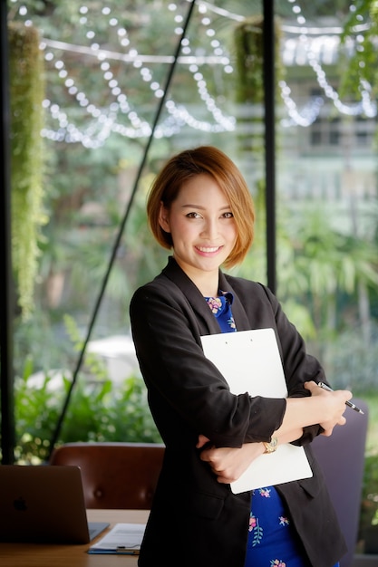 Asian businesswoman working in office with smile on face.