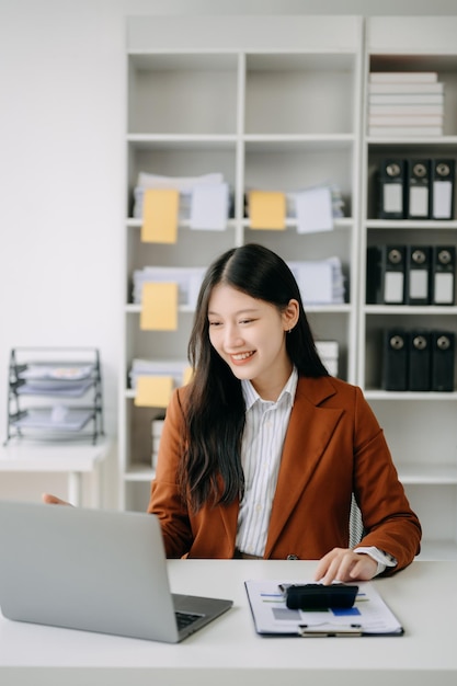 Photo asian businesswoman working in the office with working notepad tablet and laptop documents in office