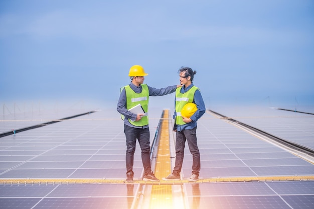 Photo asian engineer using tablet checking in solar power system for industrial ecology control top roof factory