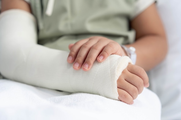 Photo asian girl in hospital with broken arm