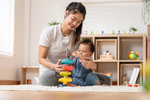 Photo asian mom teaching baby boy learning and playing toys for development skill at home or nursery room happiness mother and baby spending time together at warmth place good moment with mom and baby