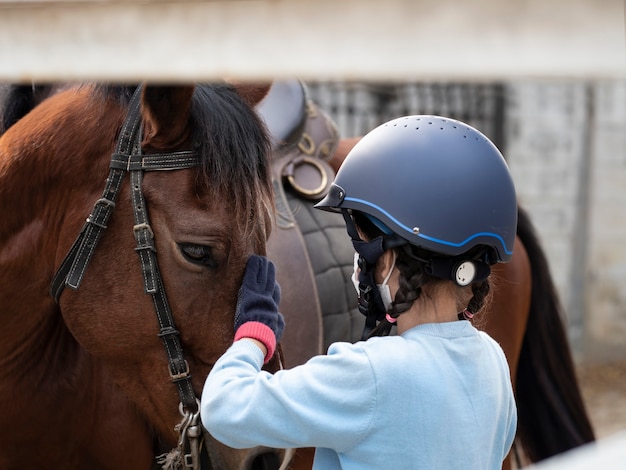 Asian school kid girl with horse ,riding or practicing horse ridding at horse ranch.