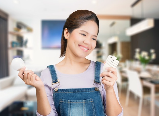 Photo asian woman holding light bulbs