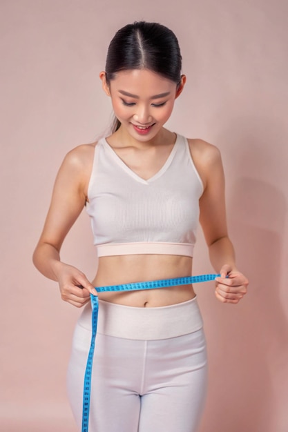 Photo asian woman measuring her waist by blue measure tape