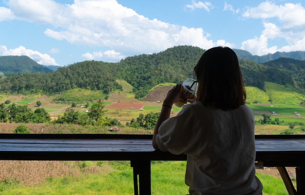 Asian woman sit and drink coffee.