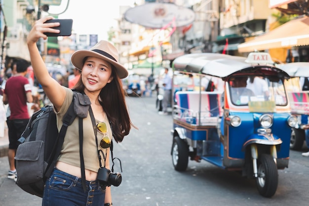 Photo asian woman tourist backpacker travel on road