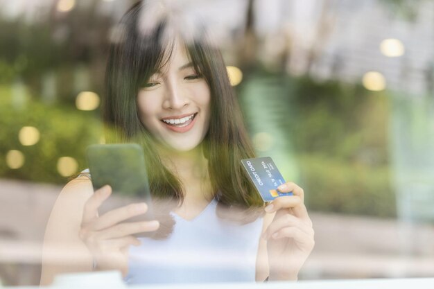 Photo asian woman using credit card with mobile phone for online shopping